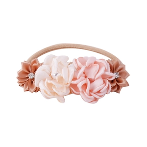 Close-up of handmade fabric flowers and rhinestones on elastic baby headband