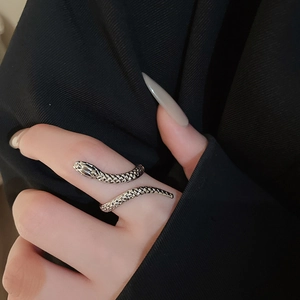 Close-up of a silver snake ring with scale textures on a model's finger