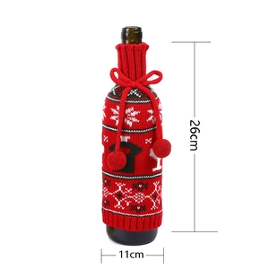 Knitted Christmas wine bottle cover with size measurements in red and green