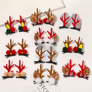 Detailed view of Christmas reindeer antler hair clips with festive bells and plaid bows