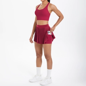 Détail d'une jupe de sport rouge avec poche de téléphone cachée et design plissé