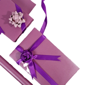 Detail showing lilac purple pearlized gift wrapping paper with matching satin ribbon and bow