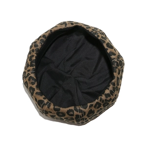 Detailed interior view of a leopard print beret hat with black fabric lining