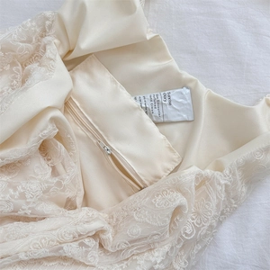 Detailed view of cream lace tote bag featuring intricate floral lace and inner zipper pocket