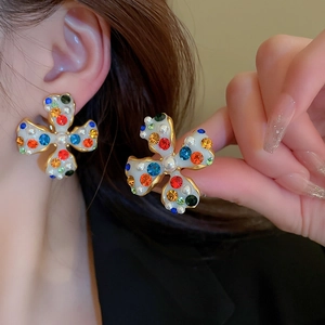 Close-up of gold-plated flower ear cuff with colorful gemstones and small pearls detail