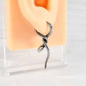 Close-up of vintage silver snake hoop earring with detailed scales on a silicone ear model