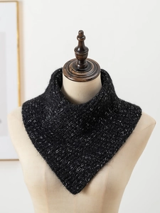 Close-up of black cable knit scarf with shimmering fibers on a beige mannequin