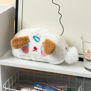 Détail de la trousse de maquillage chien en peluche avec broderie et pompon blanc doux