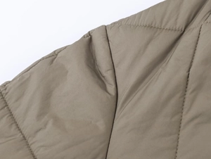 Close-up of olive green quilted jacket showing detailed stitching and durable fabric