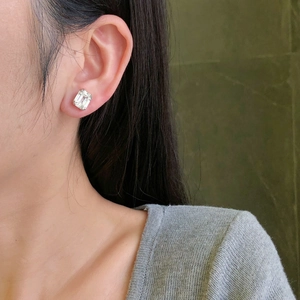 Close-up of S925 sterling silver emerald cut zircon stud earring worn on model
