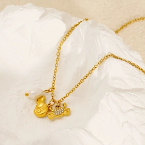 Golden stainless steel necklace with pearl shell and crab pendants on white stone