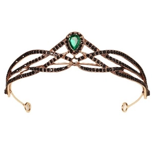 Close-up of rose gold tiara featuring black zircon stones and a green pear-cut emerald