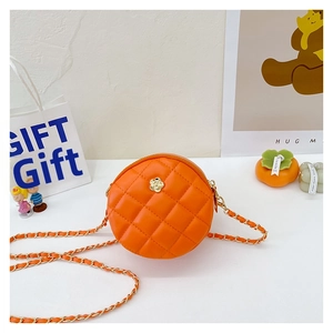 Macro detail of orange quilted mini crossbody bag with gold flower clasp and metal chain