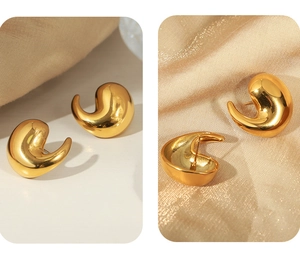 Detail of elegant gold-plated titanium earrings with a polished fluid waterdrop design
