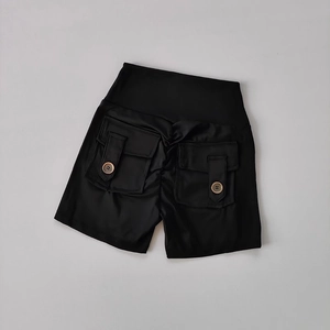 Détails à plat du short de yoga noir taille haute avec poches cargo et boutons marrons