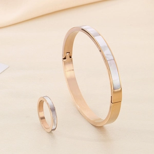 Detail of rose gold bracelet and ring set featuring white mother of pearl inlay
