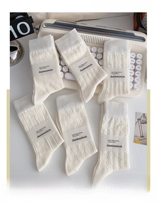 Dettaglio di calze in cotone crema con vari motivi a maglia traforata in stile vintage
