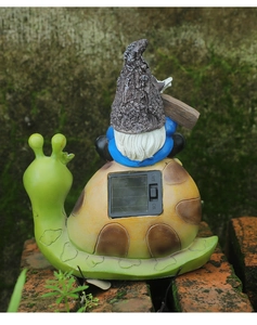 Detail showing the solar panel and ON/OFF power switch on the back of the snail gnome statue