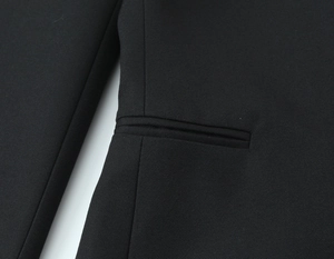 Détail du tissu tissé noir avec une poche passepoilée précise et des coutures de qualité