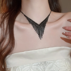 Gros plan sur le collier noir en V à franges avec décor carré sur mannequin