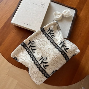 Close-up of floral lace embroidery and metal zipper on this vintage beige vanity bag