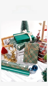 Détail de rouleaux de papier cadeau de Noël avec motifs écossais, rennes et rubans