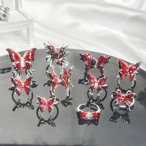 Macro view of butterfly rings set with red enamel and crystals on silk background