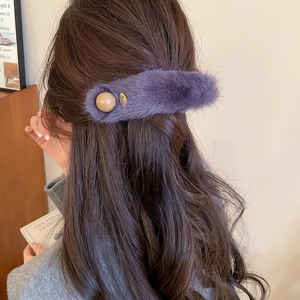 Detail of purple plush hair clip with acrylic bead and metal plate on back hairstyle