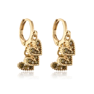 Detailed macro view of 18K gold plated tiered heart earrings with olive green zircons