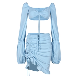 Détail du haut court bleu clair à col en V et de la mini-jupe à cordon assortie