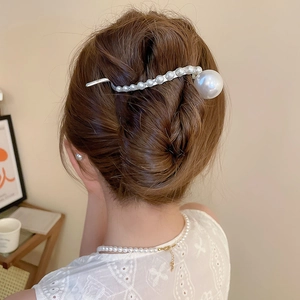 Close-up of elegant pearl hair pin set in a bridal hairstyle with silver alloy details