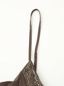 Detailed close-up of dark brown beaded sequins and thin straps on a summer mini dress