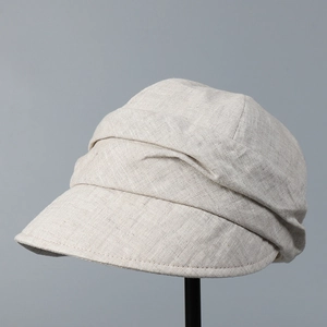 Detailed close-up of pleated beige linen fabric texture and fine stitching on a sun hat