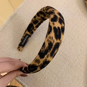 Detail of leopard print fabric headband featuring a hand made woven label and texture