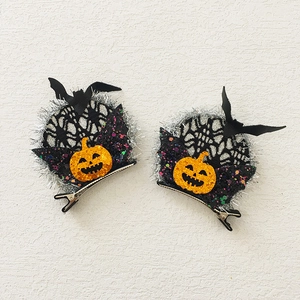 Detail of Halloween hair clips featuring glittery pumpkin faces and bat wing motifs