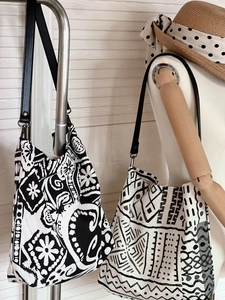 Detail of bohemian black and white linen tote bag with geometric patterns and leather straps