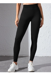 Detail of high waist black yoga pants featuring ribbed texture and slim fit athletic design