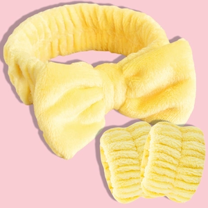Close-up of a soft yellow coral fleece headband with bow and matching wristband set