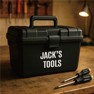 Detailed view of black matte tool box with white Jack's Tools text on a wooden workbench