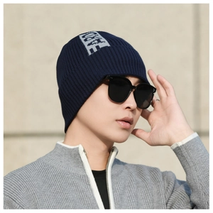 Detail of dark blue ribbed knit beanie with grey FEAR letter jacquard design
