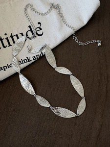 Detailed view of silver bohemian waist chain with hammered metal leaf patterns and clasp