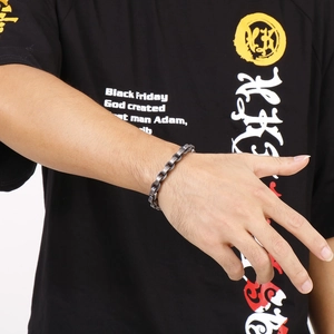 Détail d'un bracelet gourmette argent vintage au fini mat porté par un mannequin homme