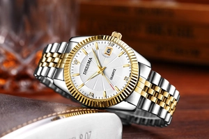 Detail of two-tone luxury quartz watch with white sunray dial and fluted gold bezel