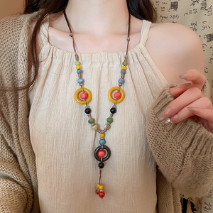 Detailed close-up of handmade ethnic ceramic bead necklace with woven rope and wooden rings