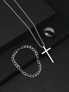 Détail d'un ensemble vintage argenté avec collier croix, bracelet cubain et bague