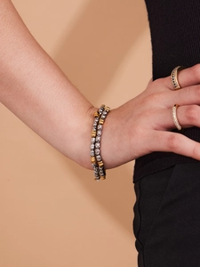 Detail of layered gold and silver beaded bracelets with sparkling cubic zirconia rings