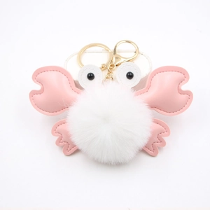 Detail of cute crab pompom keychain with white plush ball and pink faux leather claws