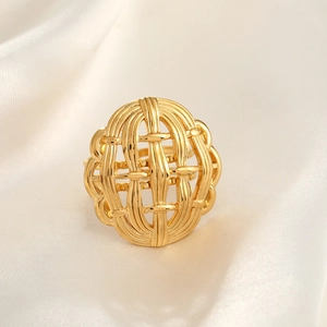Detailed view of wide gold woven open ring on soft white silk background fabric