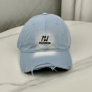 Detail of distressed light blue cotton baseball cap with MJ FASHION embroidery and torn edges