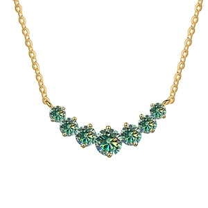 Elegante collana d'oro con sette pietre di moissanite verde graduate su sfondo bianco puro